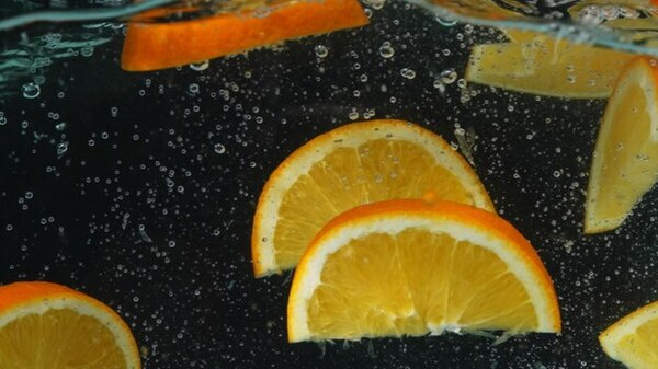A glass of water with citrus slices in soft natural light